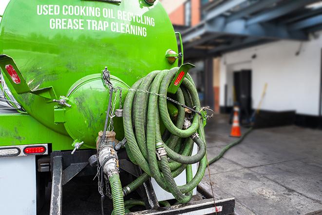 grease trap being pumped out by service technician in Avondale